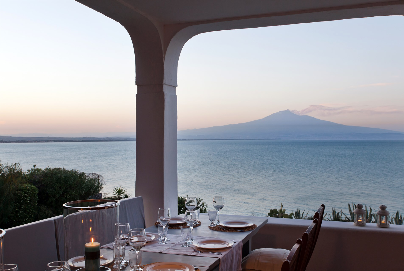 al fresco dinner with sunset view behind Mount Etna